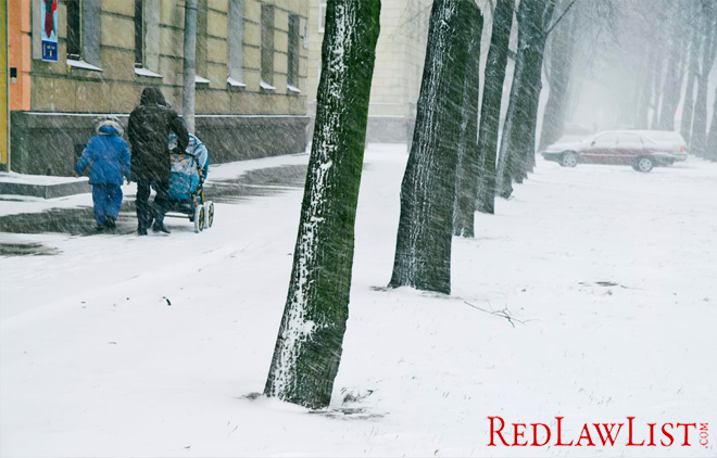 Mother and children walk on snowy sidewalk