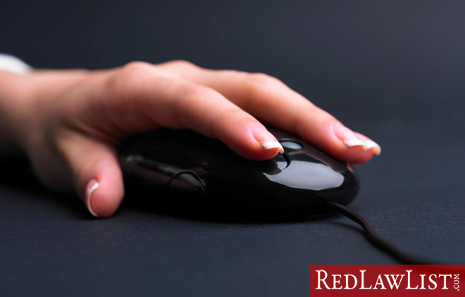 hand on computer mouse for an illegal online search